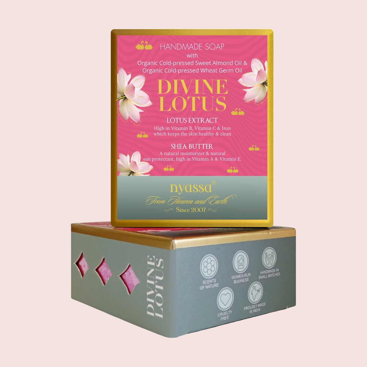 A boxed handmade soap product shown on a plain light beige background. The top box is pink with gold trim and white lotus flower illustrations, reading 'DIVINE LOTUS' and 'HANDMADE SOAP with Lotus Extract, Gold Pressed Wheat Germ Oil, and Shea Butter.