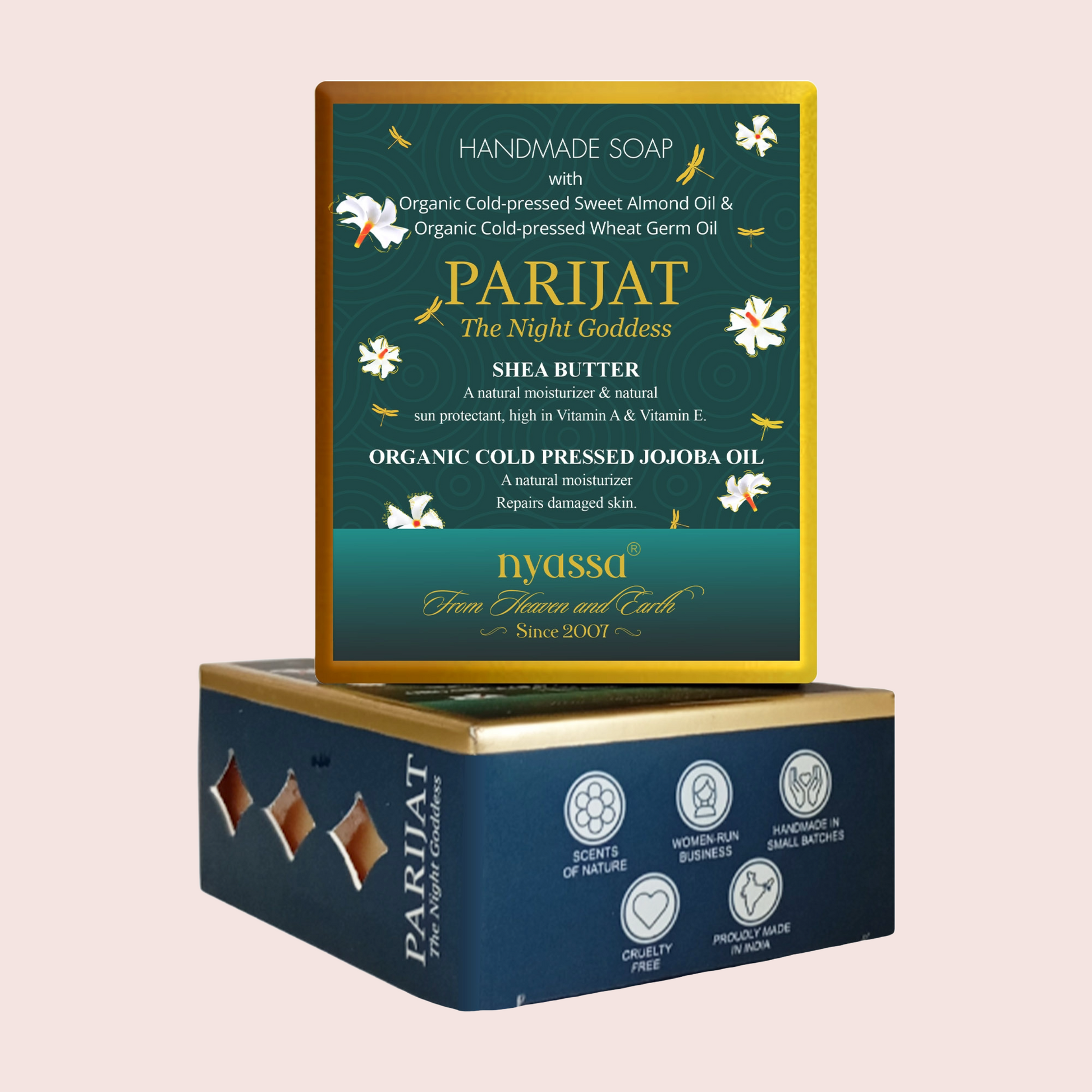 A boxed handmade soap product shown on a plain light pink background. The top box is the front-facing soap package with a dark teal-green label, gold border, white floral illustrations, and the brand name PARIJAT The Night Goddess.