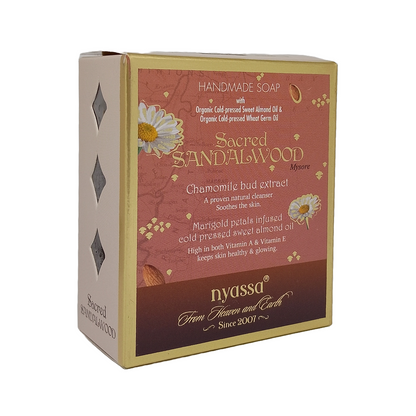 Nyssa Sacred Sandalwood Handmade Soap box, featuring a terracotta pink and dark brown label with gold lettering and white daisy illustrations, set against a plain white background.