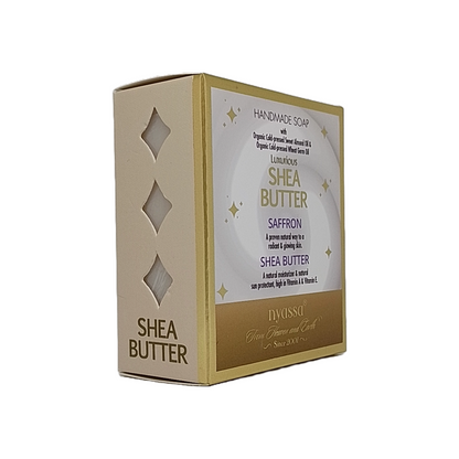 A boxed handmade soap product labeled 'Shea Butter' with 'Saffron' text, shown on a plain white background. The box is cream/beige with gold trim and a white front panel featuring gold and purple text.