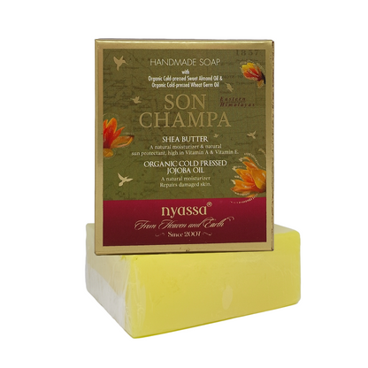 A bar of Nyossq Son Champa handmade soap resting on its cardboard packaging box, set against a plain white background.