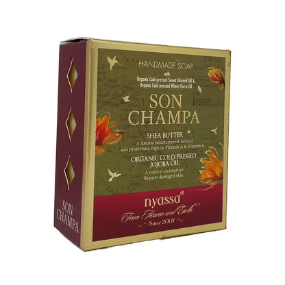 Nyassa Son Champa Handmade Soap box, featuring a green and burgundy design with gold foil accents and illustrations of lotus flowers and birds, set against a plain white background.