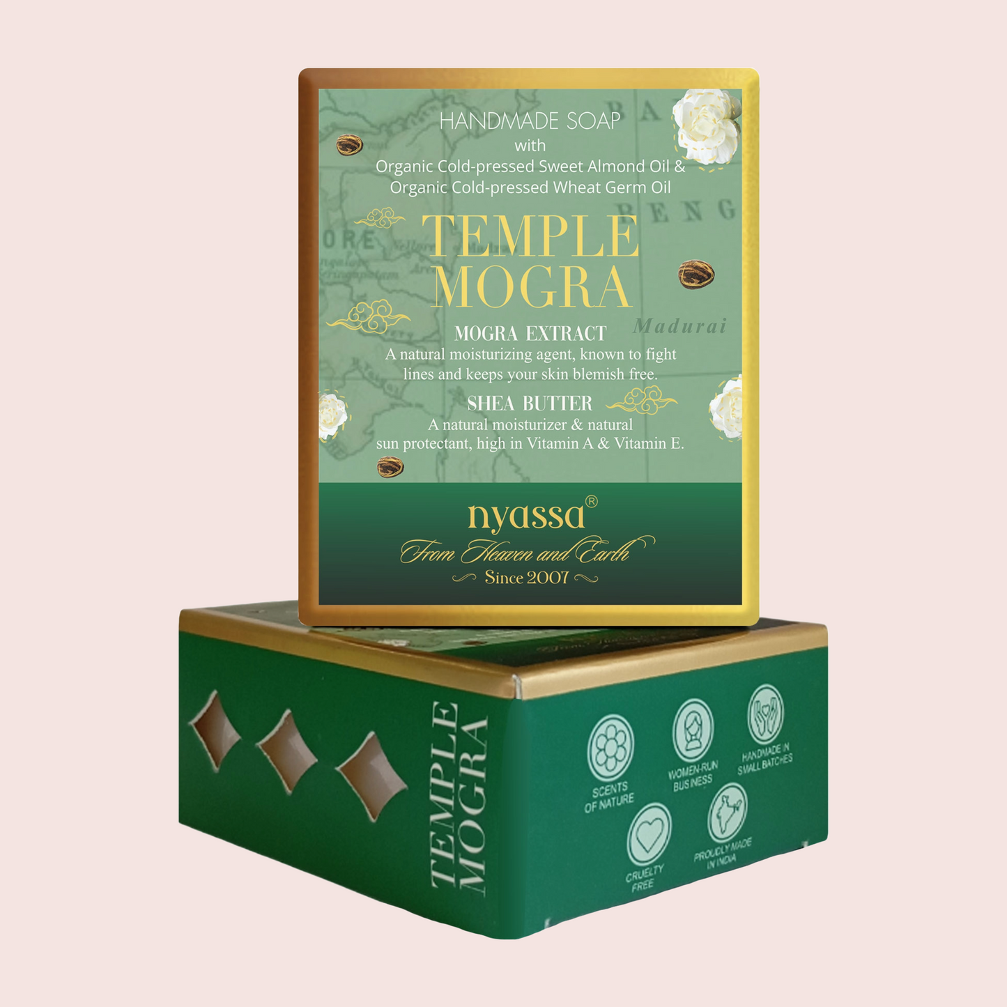 A boxed handmade soap product shown with the front label standing upright on top of the carton. The packaging is predominantly green with gold and white text and floral accents.