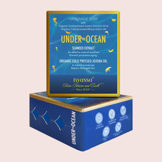 A boxed handmade soap product shown on a plain light beige background. The top box is the front label facing the camera, reading 'UNDER THE OCEAN' with blue gradient artwork and yellow text.